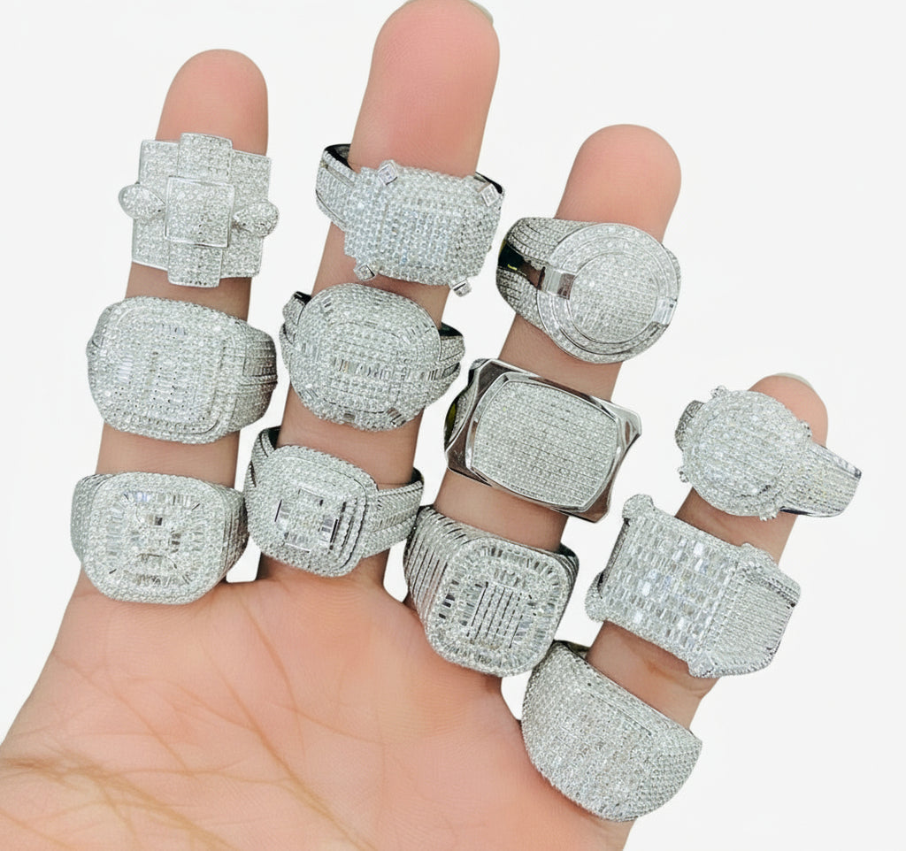 Multiple silver rings with gemstones on a hand against a white background
